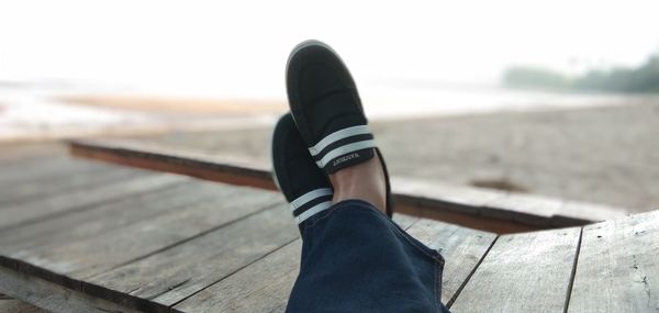 Low section of person relaxing on wood