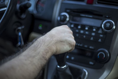 Close-up of cropped man driving car