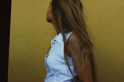 Young woman standing on wall