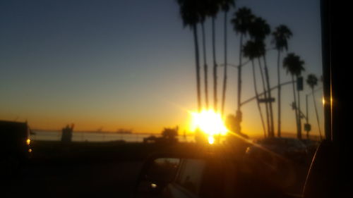 Close-up of cars on road against sunset sky
