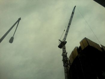 Low angle view of crane against sky