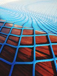 Full frame shot of blue net on wooden table