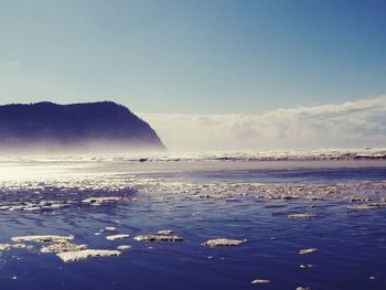 Scenic view of beach against clear blue sky