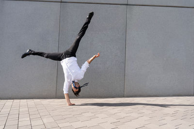 Rear view of man jumping on street