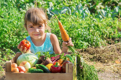 Portrait of cute boy playing with vegetables in basket