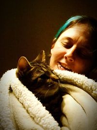 Close-up of young woman with cat at home