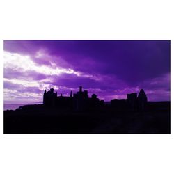 Silhouette buildings against sky at sunset