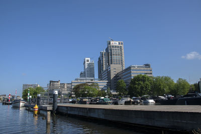 City buildings by river against clear sky