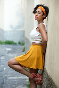 Portrait of woman standing against wall