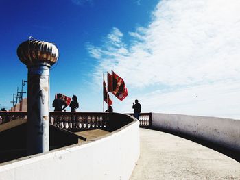 People by sea against sky