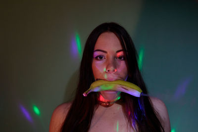 Digital composite image of beautiful young woman holding banana with smoke