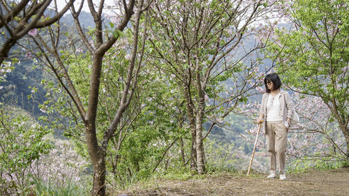 Full length of woman standing on tree