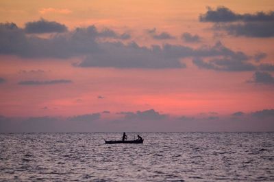 Silhouette of boat in sea at sunset
