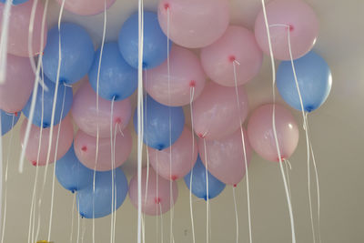 Low angle view of helium balloons against ceiling