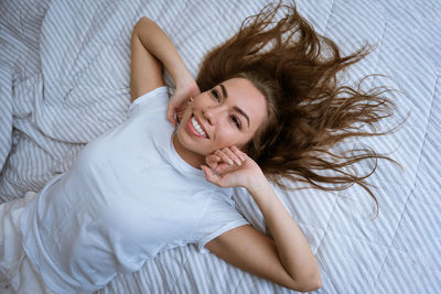 Portrait of woman lying down on bed