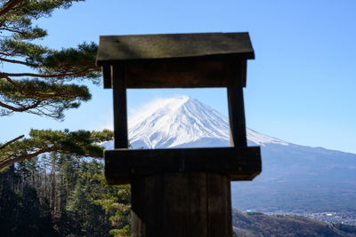 Built structure on snowcapped mountain against sky