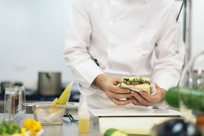 Midsection of man preparing food in restaurant