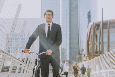 Young man riding bicycle on building in city