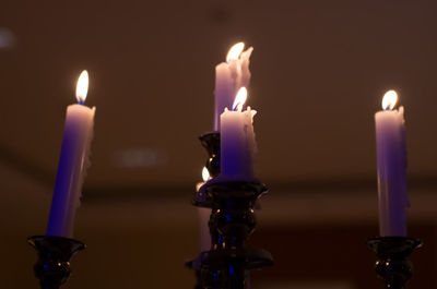 Close-up of lit candles against wall