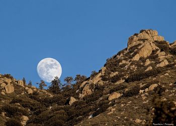 Low angle view of rock formation against clear blue sky