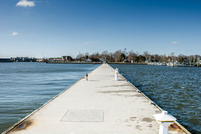 Scenic view of pier at river against sky