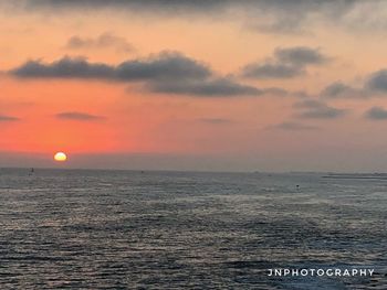 Scenic view of sea against orange sky