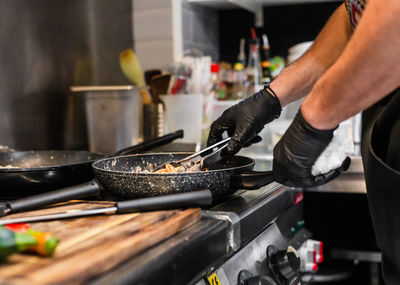 Midsection of man preparing food in kitchen