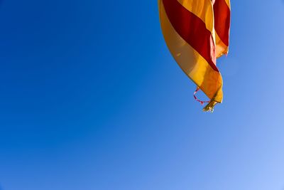 Low angle view of catalunya flag against clear blue sky