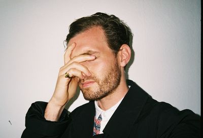 Portrait of man with hand covering face, failure