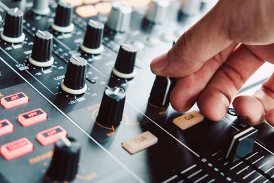 Cropped hand of musician adjusting sound mixer