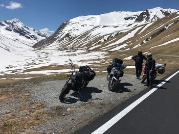 People riding bicycles on snowcapped mountains against sky