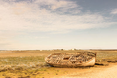 Abandoned wooden old boat wreck on a dry sea due to climate change