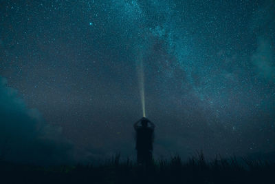 Rear view of silhouette person standing on field against sky