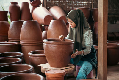 Rear view of woman standing in pots
