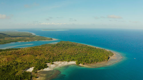 Coastline of tropical island balabac covered with green forest against the blue sky 