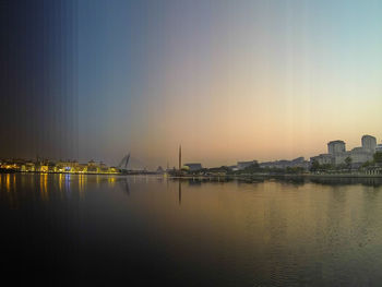 Reflection of buildings in water at sunset