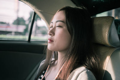 Close-up of young woman in car