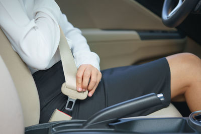 Midsection of woman sitting in car