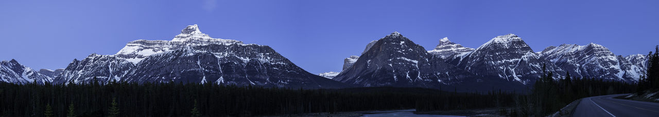 Panoramic shot of snowcapped mountains against blue sky