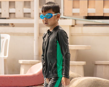 Boy in swimwear standing at poolside