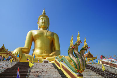 Low angle view of statue against temple building against sky