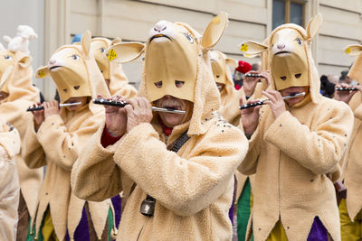 People wearing costume while playing musical instrument in carnival