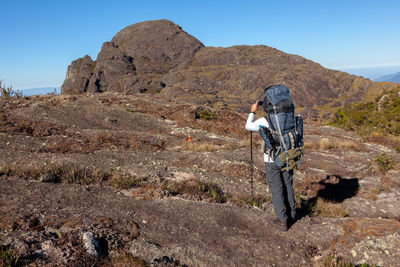 Man standing on rock against mountain