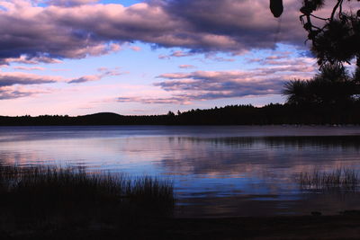 Scenic view of calm lake against cloudy sky