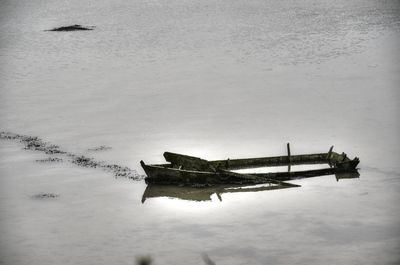 Abandoned boat in sea against sky