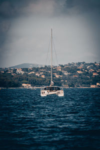 Sailboat sailing on sea against sky