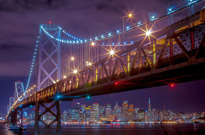 Low angle view of illuminated bridge against sky at night