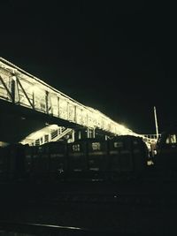 Train at railroad station against clear sky at night