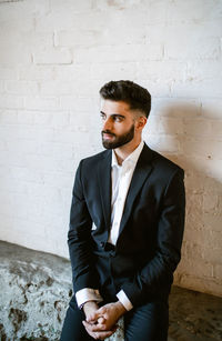 Young man standing against wall