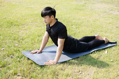 Full length of young man relaxing on field